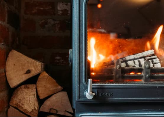 log burning stove with extra wood stacked at the side
