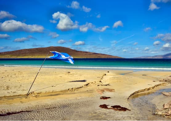 idyllic beach with scotland flag planted in sand
