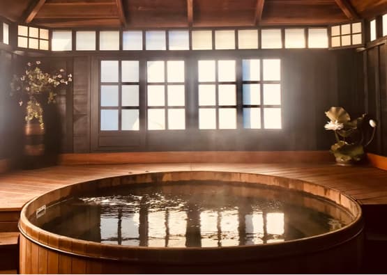 hot tub with decking and wooden holiday cottage in background