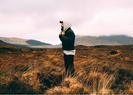 man with beard stood in long grass