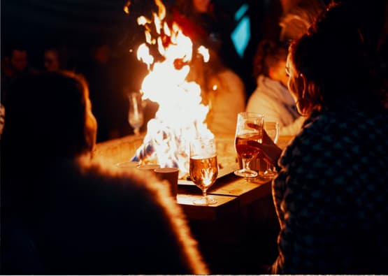 friends drinking by the fire at night