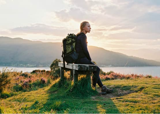 person with backpack enjoying view of ullapool