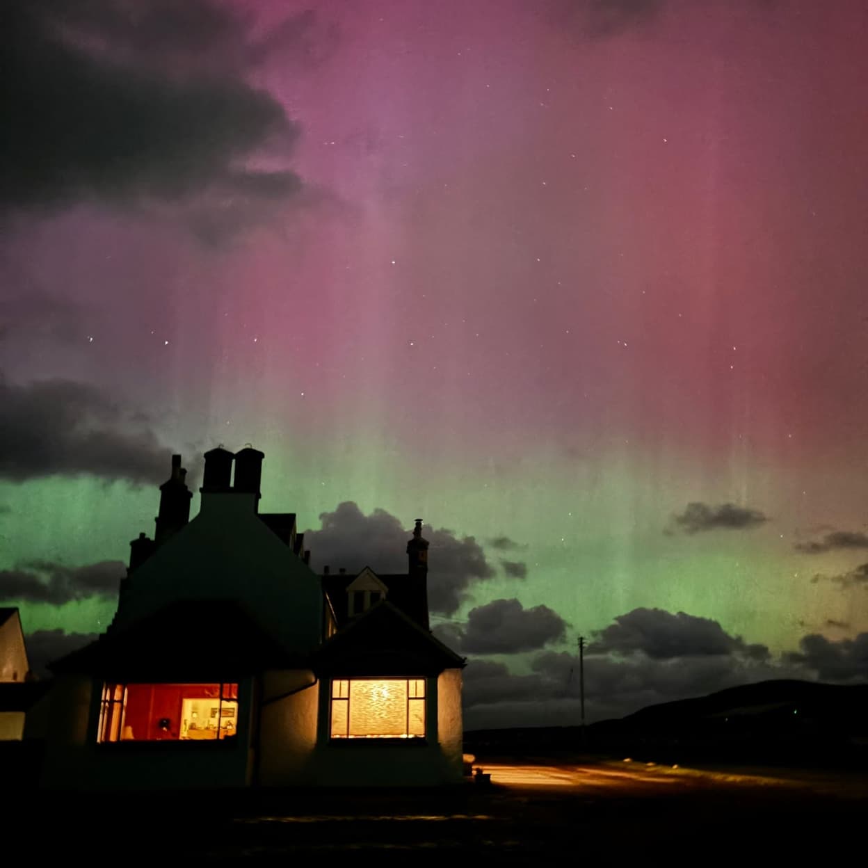A night time shot of the outside of the Lodge with the Northern Lights on show.