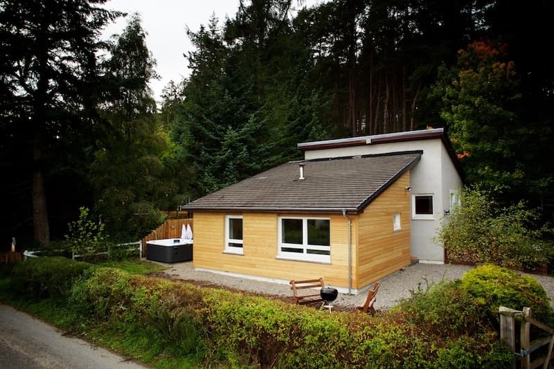 Looking towards the front of the lodge. There is timber clad extension at the front of the property. The hot tub is at the left hand side of the house