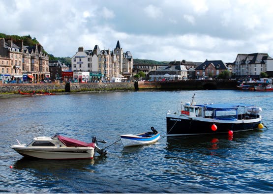 boats in oban port with town in background