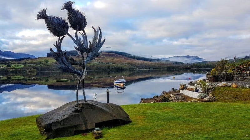 Giant thistle sculpture by Kev Paxton in the garden on Loch Earn