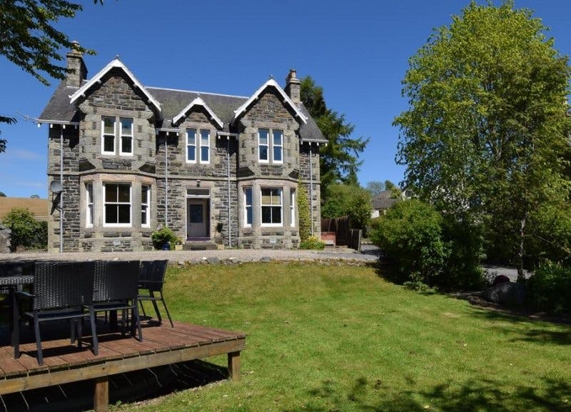 Kinnaird Country House, a Victorian villa, with front garden and hot tub on the side of the property.